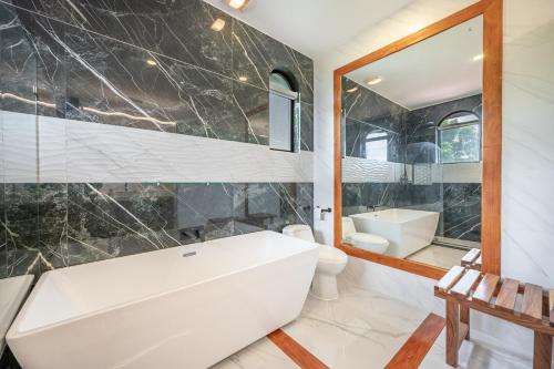 a bathroom with a tub and a toilet and a sink at Casa Vista de Paraiso in Nuevo Colón