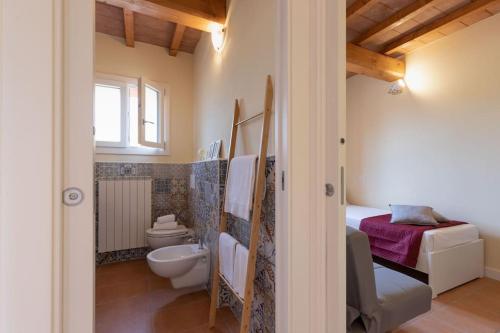 a bathroom with a toilet and a sink at Casa Melatina ToscanaOneHH in Riparbella