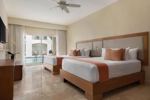 a hotel room with two beds and a pool at Sunscape Coco Punta Cana - All Inclusive in Punta Cana