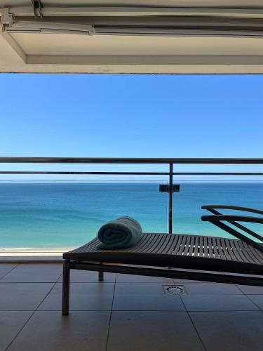 a bench in a room with a view of the ocean at Belle vue Sesimbra in Sesimbra