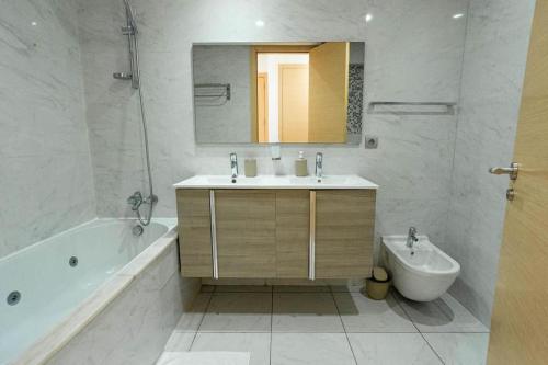 a bathroom with a sink and a tub and a toilet at Appartement avec piscine in Rabat