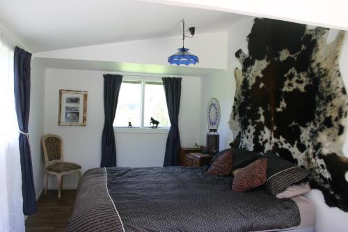 a bedroom with a bed and a window at Dream Weavers Farm Cabin in Karetu