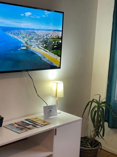 TV de pantalla plana en una pared sobre un escritorio en Hermoso apartamento en puerta de la Ciudad Vieja, en Montevideo