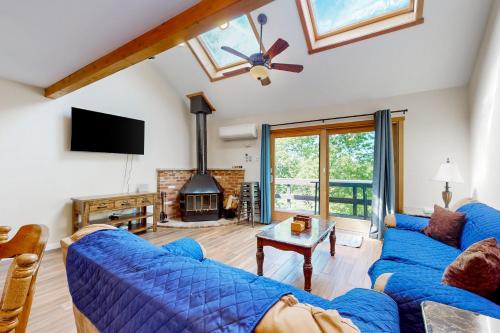 a living room with two blue couches and a fireplace at Mountain Home at Camelback in Tannersville