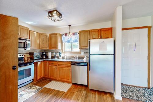 a kitchen with wooden cabinets and a white refrigerator at Mountain Home at Camelback in Tannersville