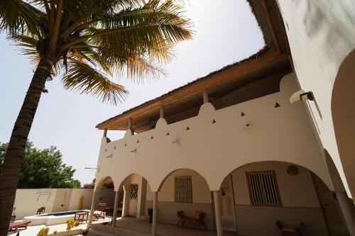 a building with a palm tree in front of it at La Teranga Toubacouta in Bani