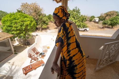 a young boy wearing a tiger print towel standing on a porch at La Teranga Toubacouta in Bani