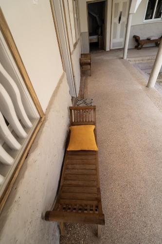 a wooden bench sitting on the side of a building at La Teranga Toubacouta in Bani