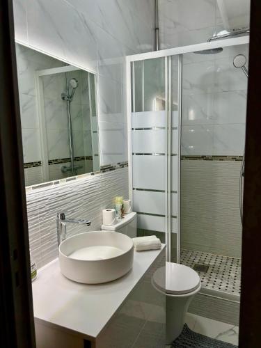 une salle de bain blanche avec un lavabo et une douche dans l'établissement Superbe appartement Paris 3ème, à Paris