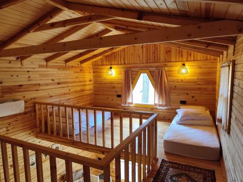 a room with a bed in a log cabin at Badece Farm Yellow House in Bergama