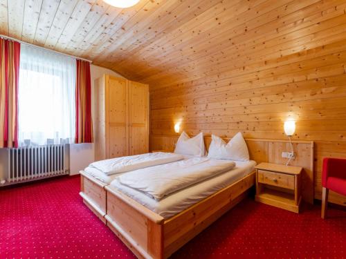 Un dormitorio con una cama grande en una habitación de madera. en Saalach, en Saalbach Hinterglemm