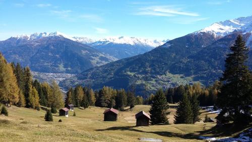 a group of huts on a hill with mountains at Haus Mattle in Pettneu am Arlberg