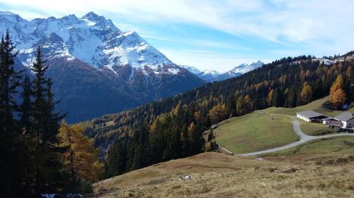a house on a hill with a snow covered mountain at Haus Mattle in Pettneu am Arlberg