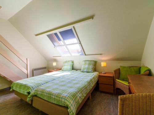 a attic bedroom with a bed and a window at Meeuwenoord in Middelkerke