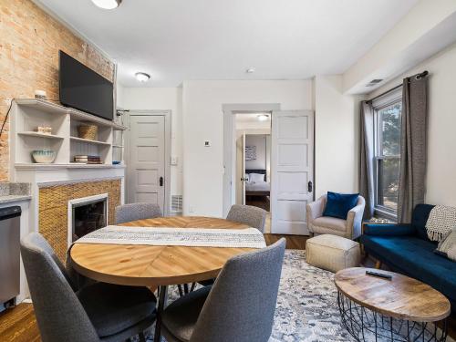 a living room with a table and a blue couch at Carriage Manor - Sun Soaked 1BR - Close to CCF in Cleveland
