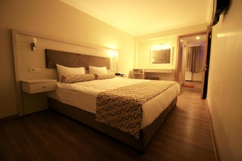 a bedroom with a large bed in a hotel room at Grand Zeybek Hotel in Izmir