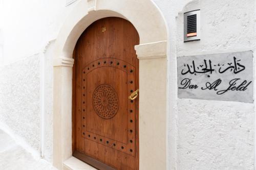 Luxurious Riad Center Rabat Dar Al Jeld في الرباط: باب خشبي في مبنى عليه لافته