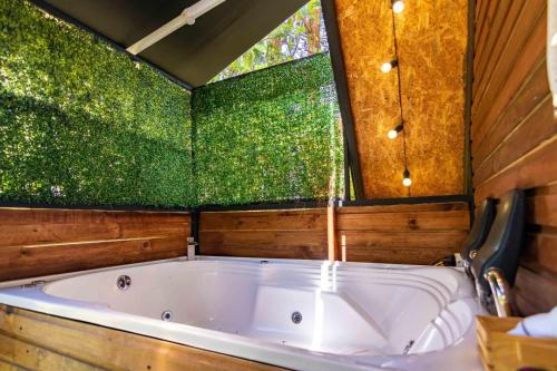 eine große Badewanne in einem Raum mit Fenster in der Unterkunft EUCALYPTO CHALET in Guarne
