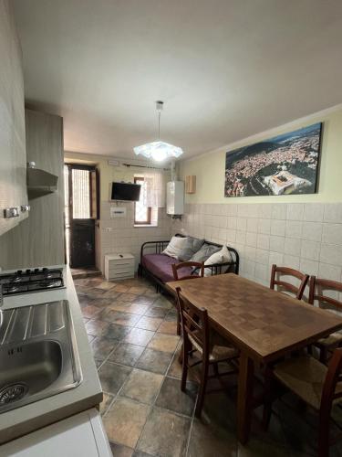 a kitchen and dining room with a table and a couch at da sciuri case vacanza Barisciano in Barisciano