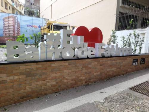a sign that says love chocolate on a brick wall at Jóia no Bairro de Fátima - Lapa in Rio de Janeiro