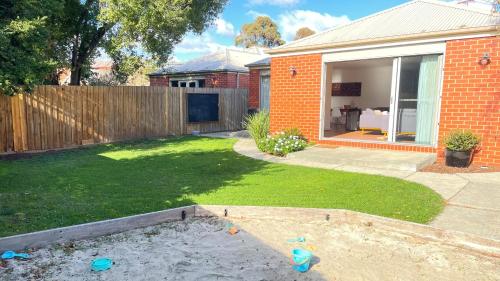 a small yard with a house with a fence at Sunbury on the Park in Sunbury
