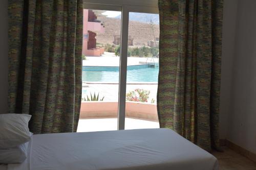 a bedroom with a window with a view of a pool at Morgenland Holly Village in Saint Catherine