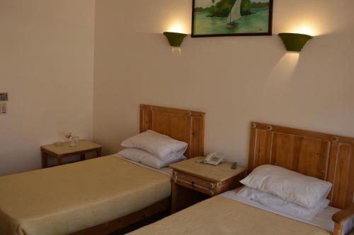 a room with two beds and a phone on the wall at Morgenland Holly Village in Saint Catherine