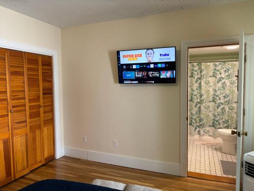 uma sala de estar com uma televisão de ecrã plano na parede em Traveler’s Den in Medford em Medford
