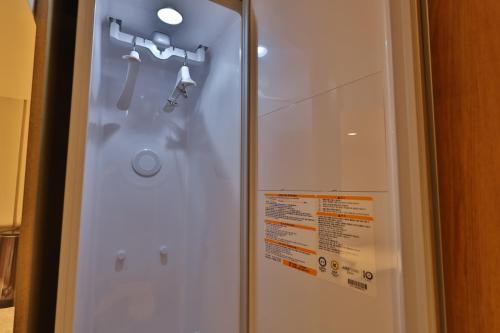 una puerta de ducha de cristal con un par de cabezales de ducha en Daegu Billion Western Hotel en Daegu