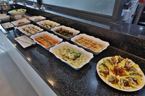 a buffet with several dishes of food on a counter at Daegu Billion Western Hotel in Daegu