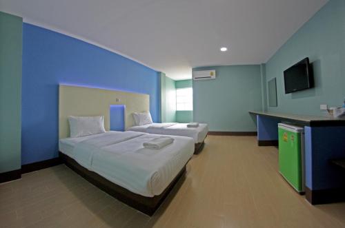 a bedroom with two beds and a blue wall at Central Park Hotel in Sing Buri