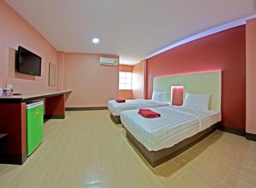 a hotel room with two beds and a flat screen tv at Central Park Hotel in Sing Buri