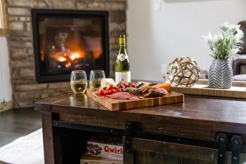 a table with a plate of food and a bottle of wine at Pine Forest Getaway, Game Room, Hot Tub, Fire Pit in Ronald