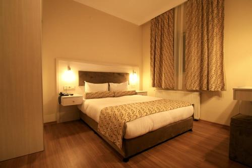 a hotel room with a bed and a window at Grand Zeybek Hotel in Izmir