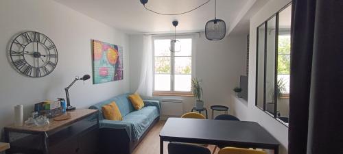 un salon avec un canapé bleu et une table dans l'établissement Actarus-SILS - T1 28 M2, à Caen