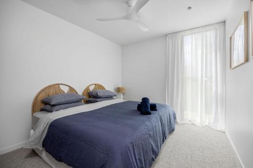 a bedroom with a bed with a blue comforter and a window at Santorini Blue Sorrento with heated spa and stunning views in Sorrento