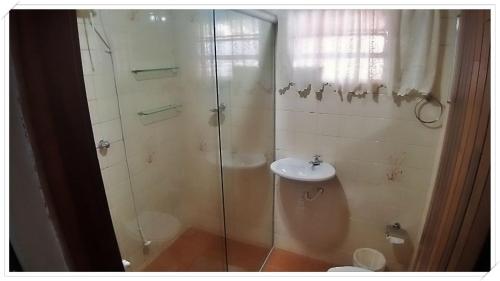 een badkamer met een douche en een wastafel bij Recanto GERMANO in Campos do Jordão