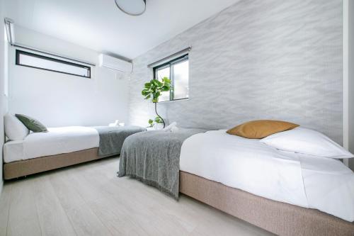 a bedroom with two beds and a window at ぷふか東向島2 in Tokyo
