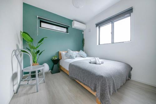 a bedroom with a bed and a chair in it at ぷふか東向島2 in Tokyo
