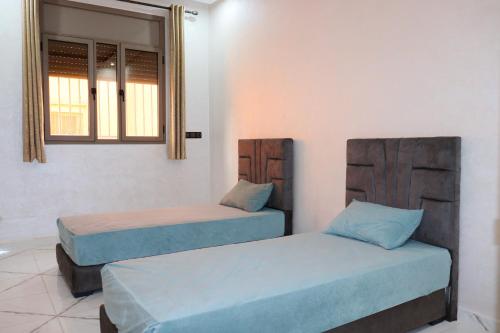 APPARTEMENT DE LUXE A LAAYOUNe في العيون: غرفة بها سريرين ونافذة