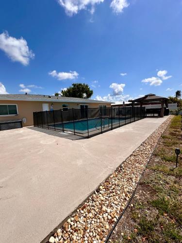 a swimming pool with a fence around a building at Rotonda Pool Oasis Near Beaches - Sleeps 9 in Rotonda West