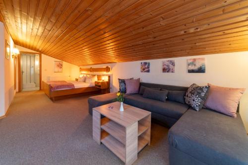 a living room with a couch and a table at Gästehaus beim Schneidersepp inkl. Chiemgaukarte in Ruhpolding