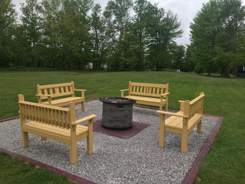 a group of benches sitting around a fire pit at A Country Home Inn the city in Charlottetown