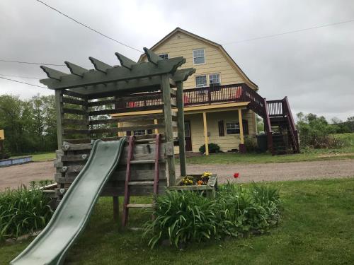 a playground in front of a house with a slide at A Country Home Inn the city in Charlottetown
