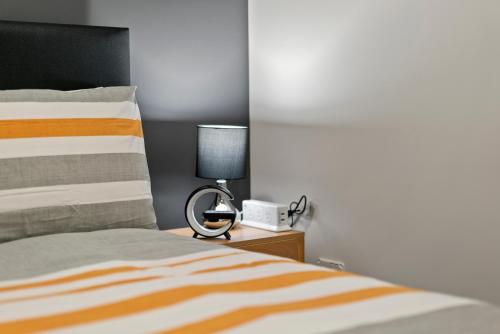 a bedroom with a bed and a lamp on a nightstand at Lux 4 Bedroom in Auckland with Spa and Light Breakfast in Auckland