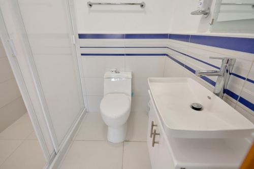 a white bathroom with a toilet and a sink at Amazing apartment close to Foro Sol Colonia Roma Airport and Downtown in Mexico City
