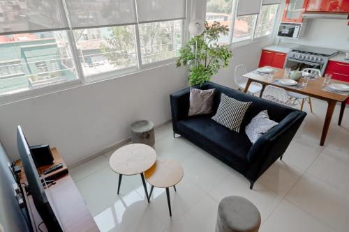 a living room with a black couch and a table at Amazing apartment close to Foro Sol Colonia Roma Airport and Downtown in Mexico City