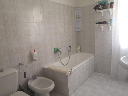un bagno con vasca, WC e lavandino di Etna Holiday Apartment - Casa Vacanze a Fiumefreddo di Sicilia