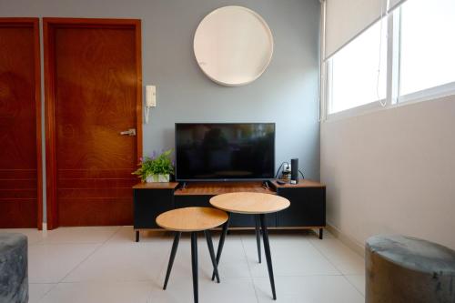a living room with two tables and a tv at Amazing apartment close to Foro Sol Colonia Roma Airport and Downtown in Mexico City