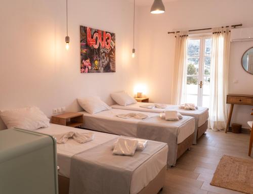 a room with four beds and a window at Amelia rooms in Batsi